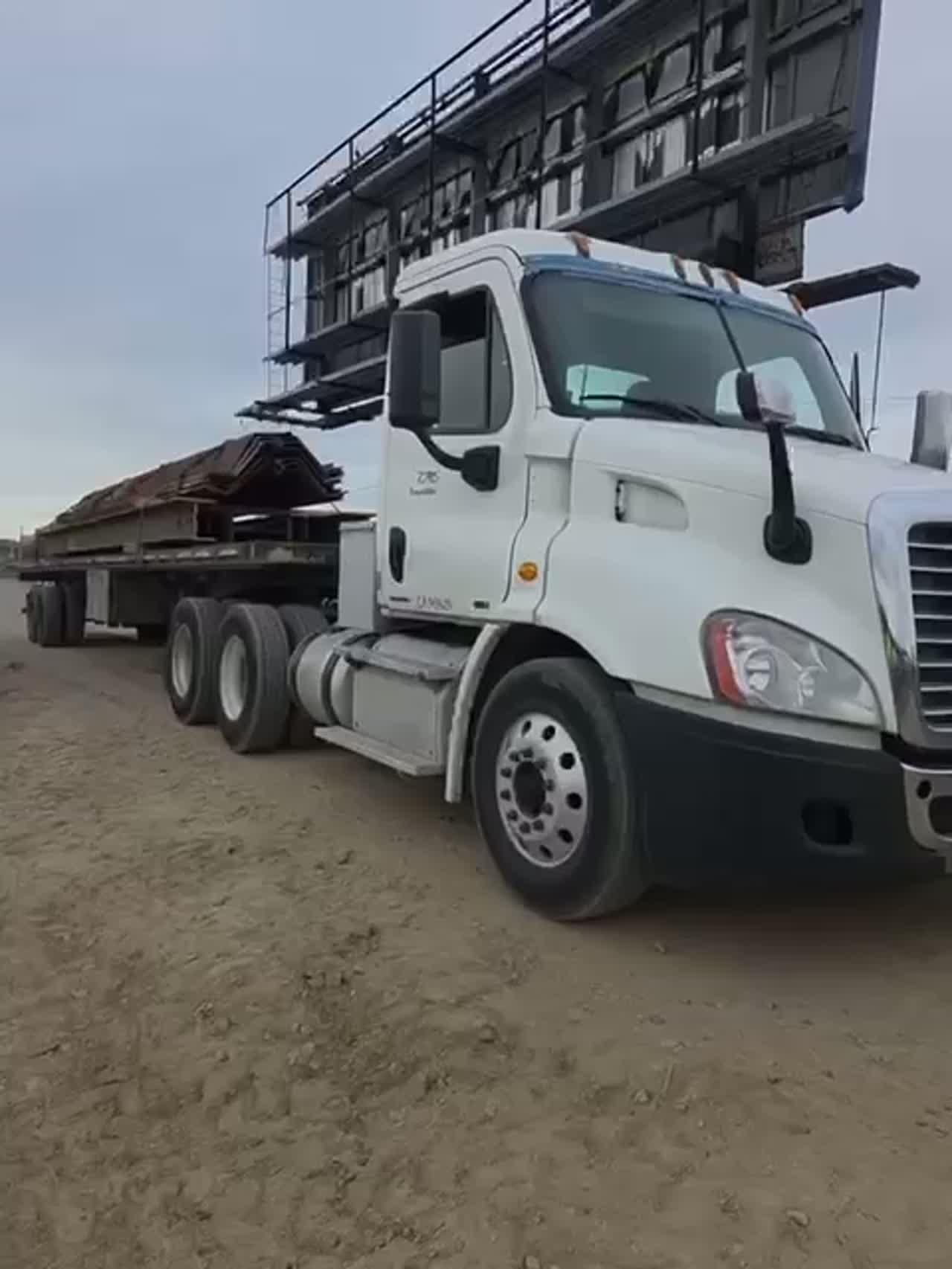 Commercial flatbed transport near rail infrastructure